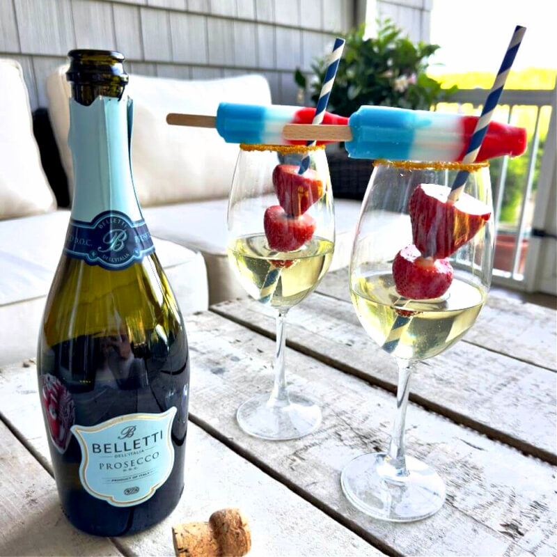 4th of July cocktail in red, white, and blue on wood table