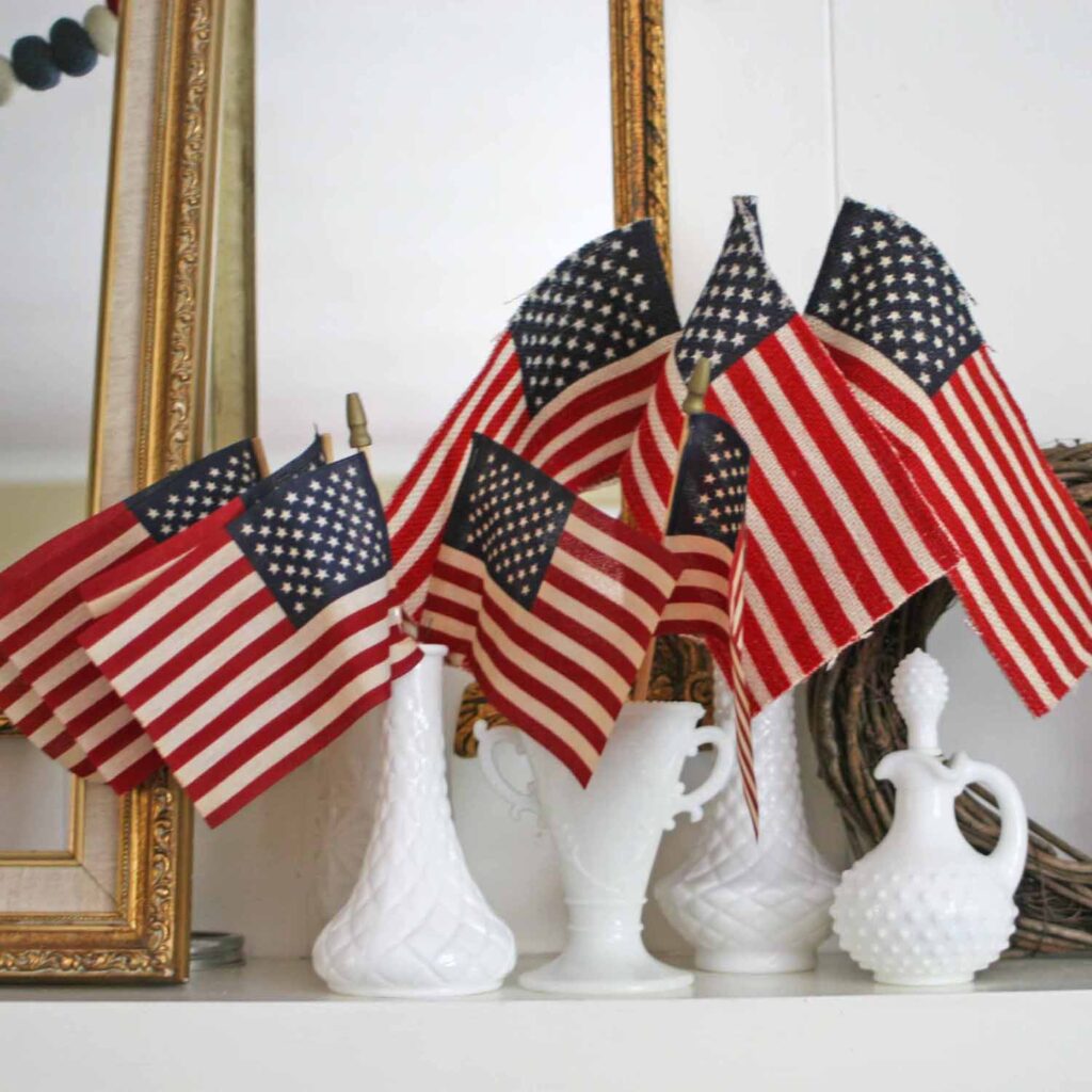 Patriotic mantel display with vintage milk glass and flags