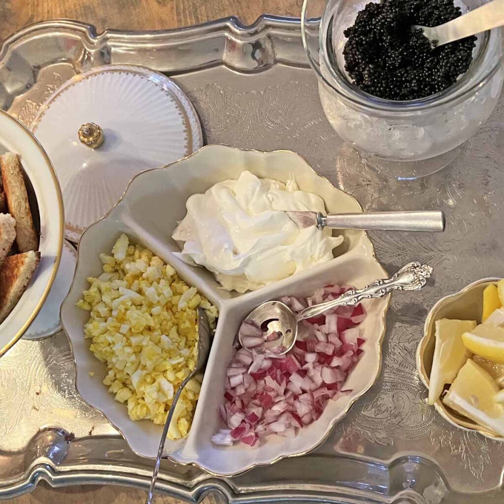 Caviar station with cream fraiche, chopped egg, red onion. on toast points garnished with lemon