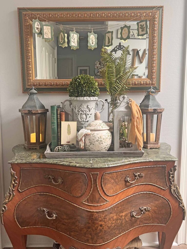 botanical summer decor vignette in the foyer full length including bombe chest
