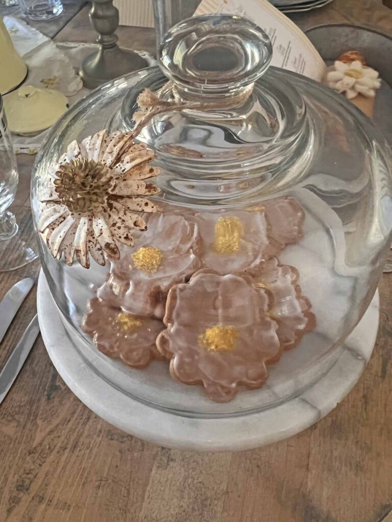 Oopsie daisy inspired tablescape ginger snaps under cloche with metal daisy bauble