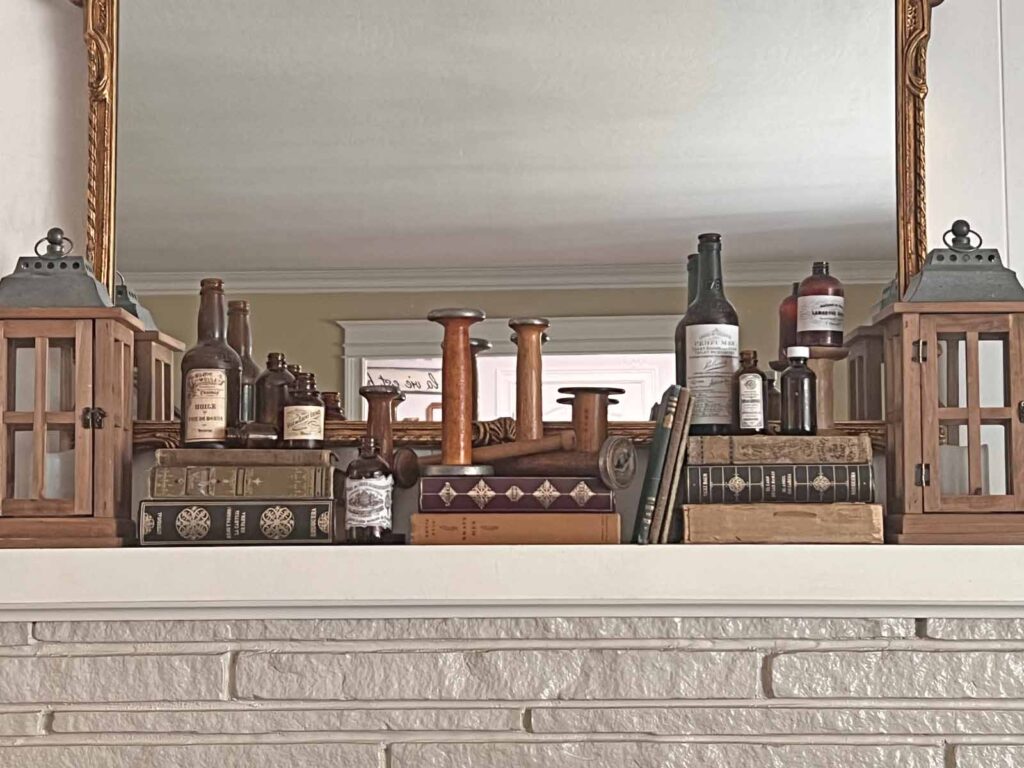Fall Mantel Decor: Embracing the Essence of Fall Slowly- books, bottles and spools laid out