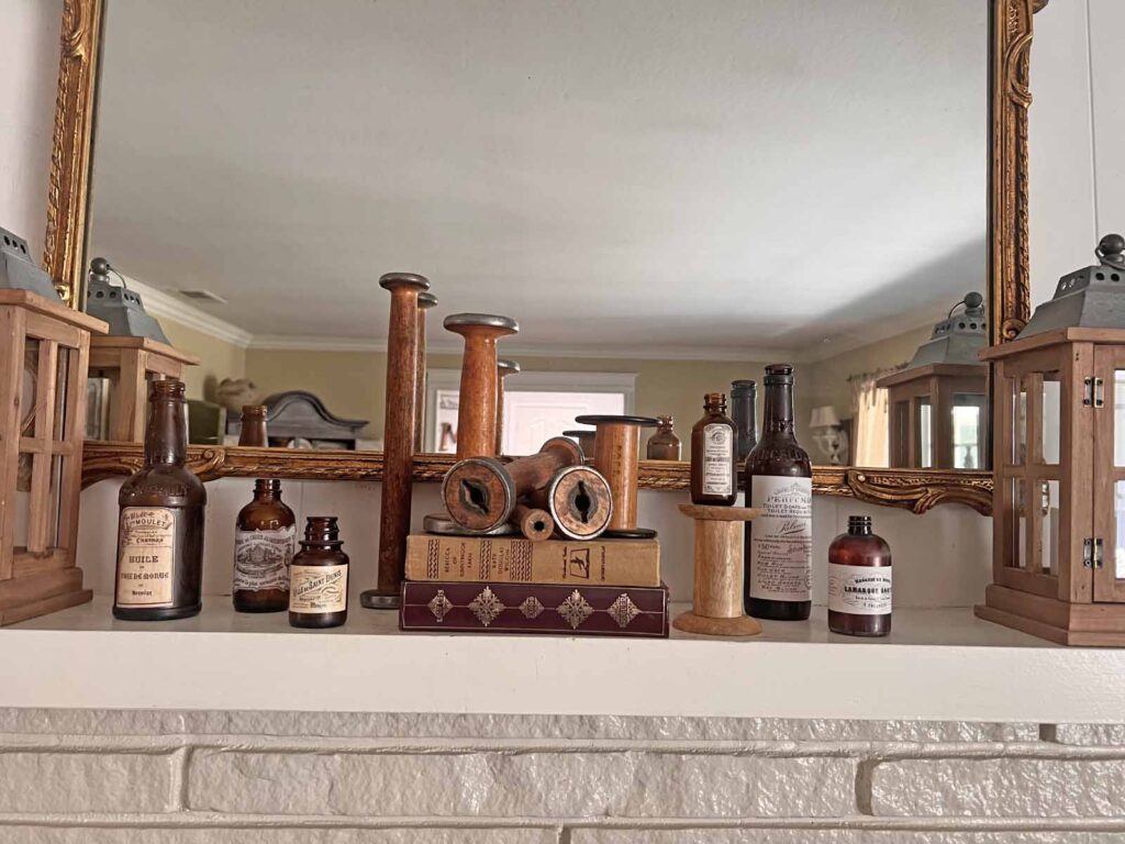 Fall Mantel Decor: Embracing the Essence of Fall Slowly- spools with books and bottles