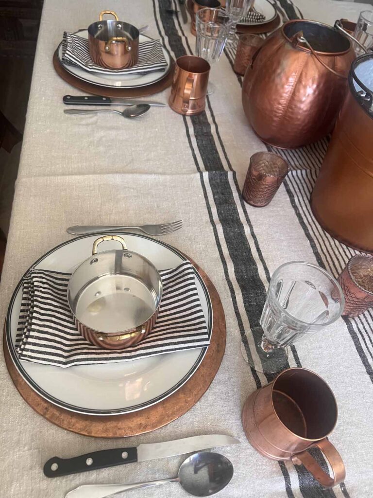 Halloween copper inspired table setting plate stack and place setting angled down the table