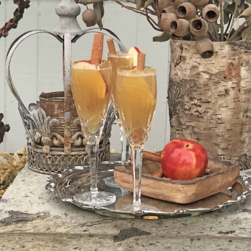 Apple cider mimosa recipe staged in front courtyard