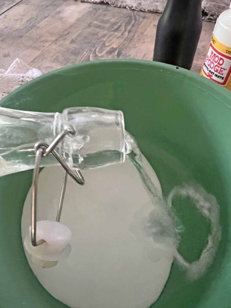 How to transform a thrifted Doily into Casper the friendly ghost for Halloween DIY pouring water into bucket with mod podge
